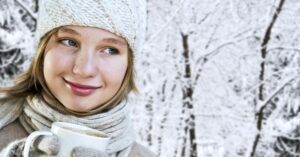 woman smiling in snow covered trees