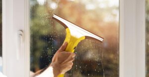Man washing windows in a home