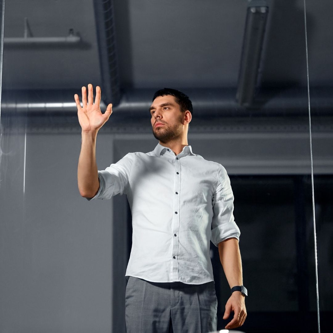 man with his hand on a clear glass wall