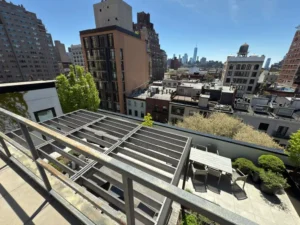 Bright Manhattan skyline viewed from a clean terrace railing after professional window cleaning.