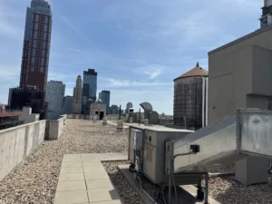 Rooftop view with city skyline and industrial structures, capturing the harsh environmental exposure NYC windows face year-round.