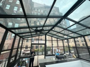 Inside a glass rooftop greenhouse — a challenging space where waterless methods make cleaning safer and simpler.
